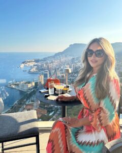 Stunning woman enjoying The Maybourne Riviera rooftop bar view over Mediterranean in Monaco.