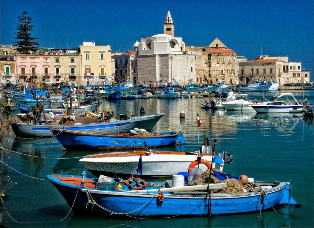 harbor and fishing boats with trani cathedral in Puglia Italy