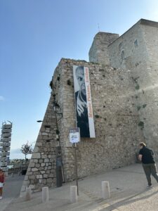 A historic stone wall featuring a prominent Picasso exhibition poster at Musée Picasso in Antibes France.