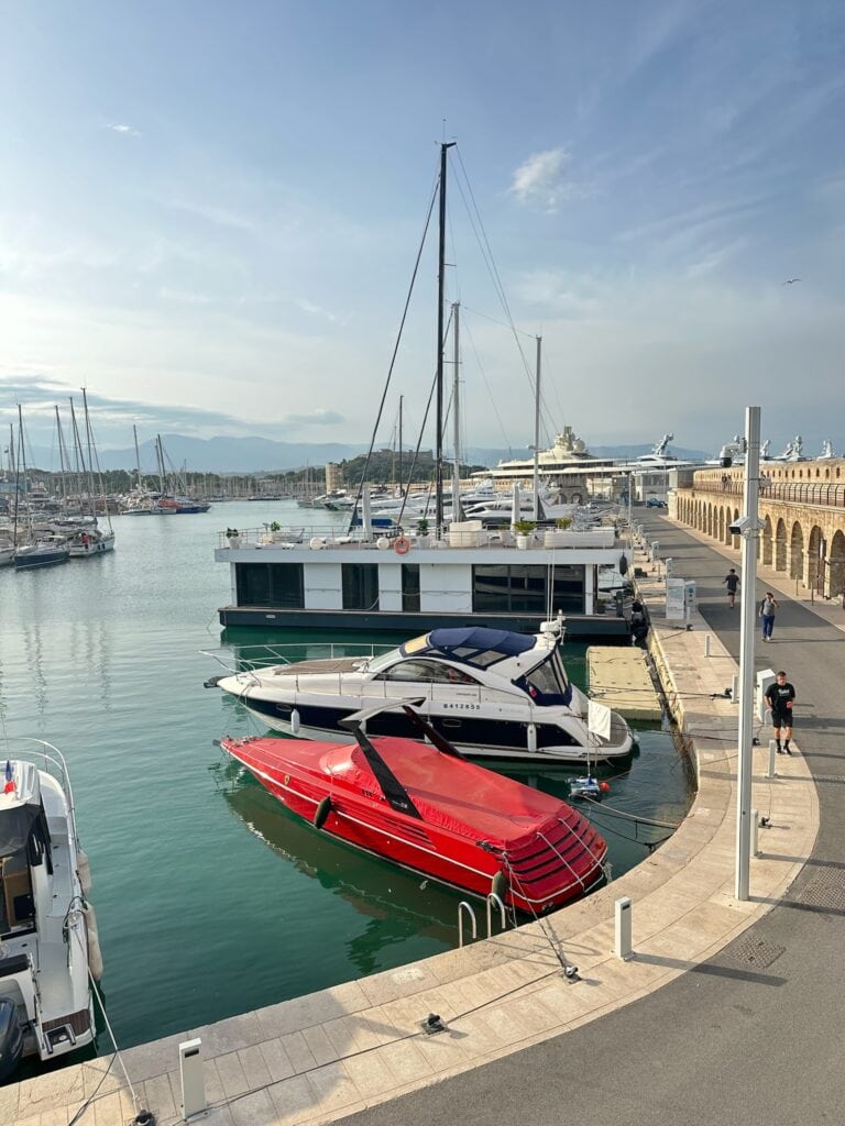 Luxurious yachts docked at a scenic marina in Antibes, France on a sunny day.