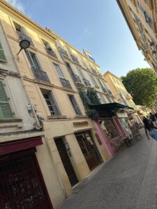 Charming street with cafes and colorful buildings in Antibes, France.