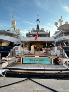Luxury yacht at a marina Saint Tropez, France, featuring outdoor seating and swimming pool area.