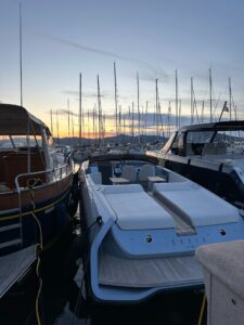 Luxury yacht moored at marina during sunset, scenic harbor with sailboats.