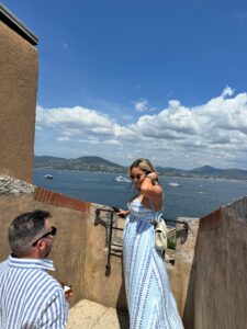 Stylish couple enjoying a scenic view of the bay with yachts and mountains, capturing memorable a moment in Saint Tropez, France.