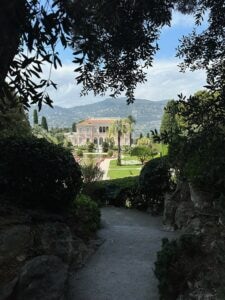 Luxurious mansion overlooking manicured gardens with mountain backdrop. Villa Ephrussi de Rothschild in Saint Jean Cap Farrat