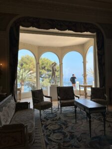 Luxurious interior with classic furniture overlooking scenic ocean view and lush greenery.