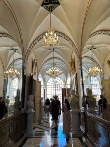 Elegant historic interior with chandeliers, statues, and arches in the Prince's Palace in Monaco.