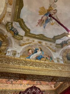 Angelic Baroque ceiling fresco with gold gilded architectural details and ornate sculptures in Prince's Palace in Monaco.
