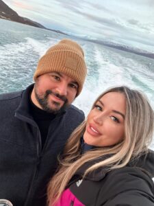 Bright couple enjoying a boat ride with snow-capped mountains in the background in Norway