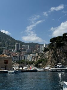 Luxurious yacht harbor with modern high-rise buildings and scenic mountain backdrop in Monaco.