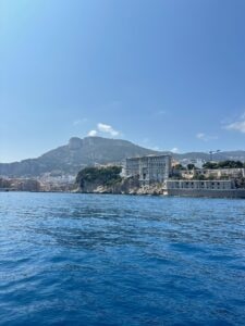 Spectacular coastline view of Monaco with luxury buildings and mountain backdrop.