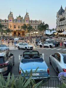 Luxurious Monte Carlo casino with vintage cars and palm trees in Monaco.