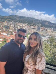Beautiful couple enjoying scenic city view in Monaco with mountains in the background, sunny weather.