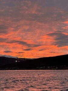 Stunning sunrise over a lake with colorful sky and silhouetted mountain range in Norway